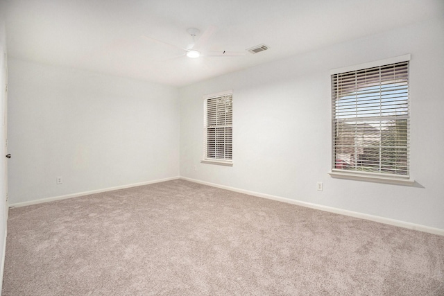 carpeted spare room with ceiling fan