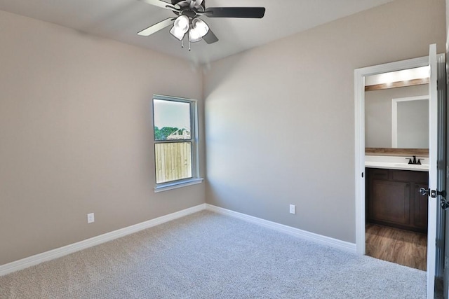 unfurnished bedroom with light carpet, ceiling fan, and sink