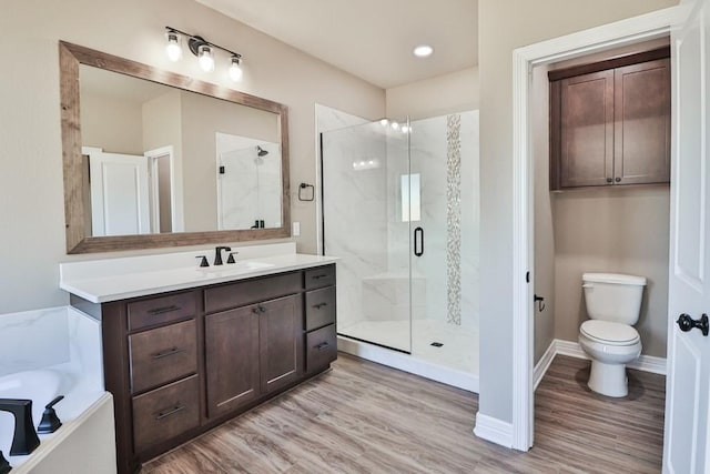 full bathroom featuring hardwood / wood-style floors, vanity, toilet, and independent shower and bath