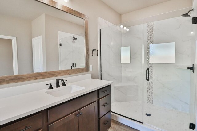 bathroom featuring vanity, a shower with shower door, and hardwood / wood-style flooring