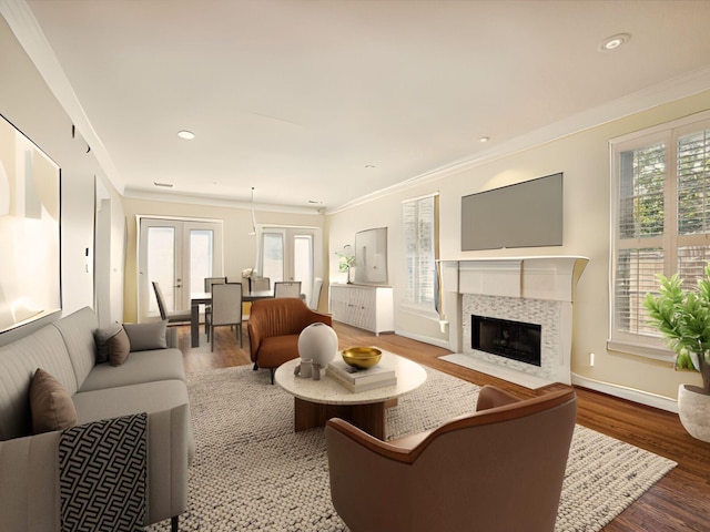 living room featuring french doors, plenty of natural light, crown molding, and a tiled fireplace