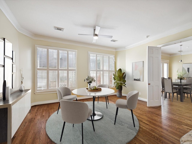 dining room with ceiling fan, dark wood-type flooring, and ornamental molding