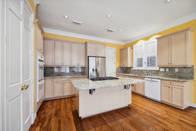 kitchen featuring appliances with stainless steel finishes, dark hardwood / wood-style flooring, backsplash, light stone counters, and a kitchen island