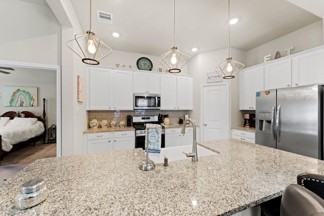 kitchen featuring decorative light fixtures, white cabinetry, and stainless steel appliances