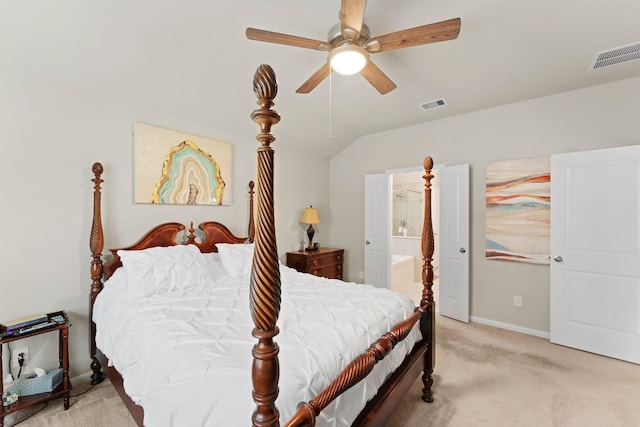 bedroom featuring ceiling fan, ensuite bathroom, vaulted ceiling, and light carpet