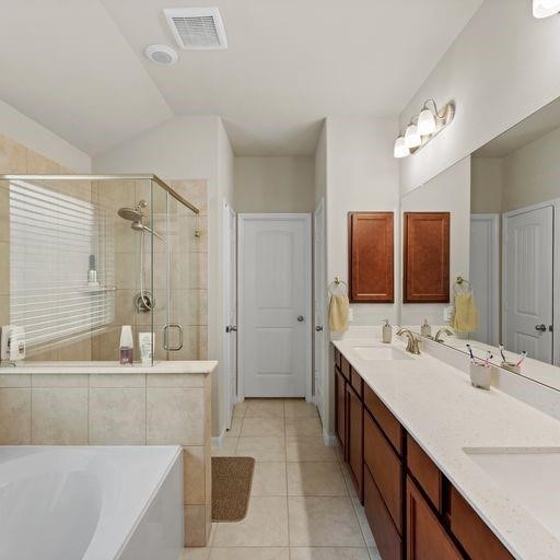 bathroom with tile patterned floors, vanity, and separate shower and tub