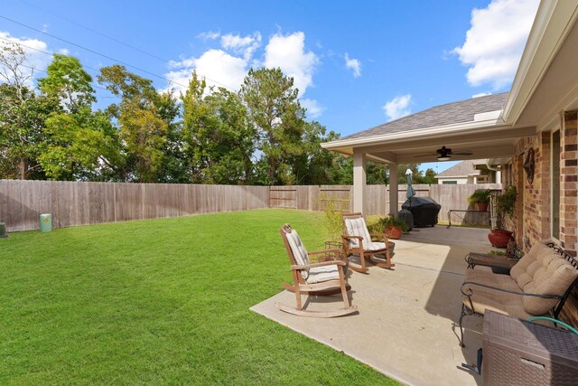 view of yard with ceiling fan and a patio