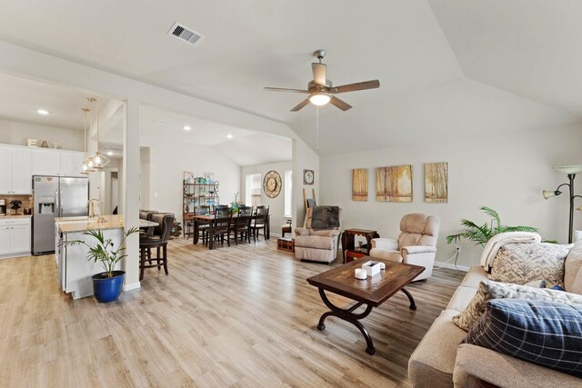 living room with light hardwood / wood-style flooring, ceiling fan, and lofted ceiling