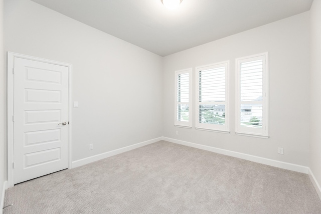 unfurnished room featuring light carpet