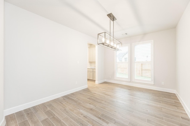 unfurnished dining area featuring light wood-type flooring