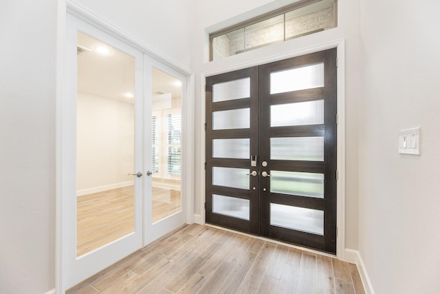 foyer with french doors and light hardwood / wood-style flooring