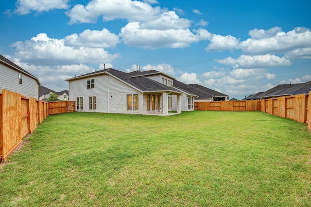 rear view of house featuring a yard