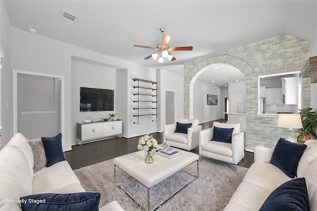 living room featuring dark hardwood / wood-style flooring, ceiling fan, and sink