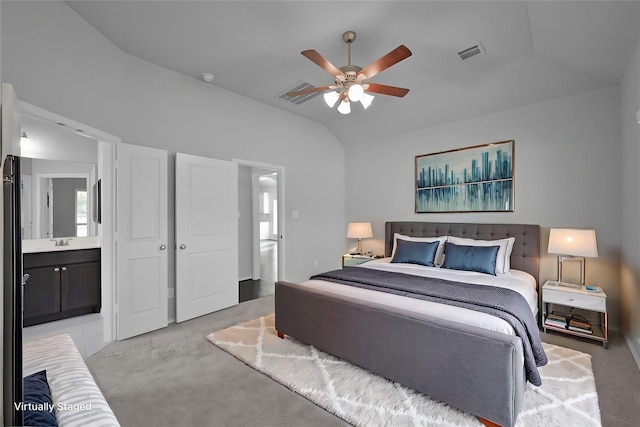 bedroom featuring ensuite bathroom, light colored carpet, ceiling fan, sink, and lofted ceiling