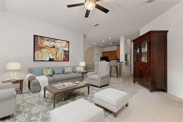 carpeted living room with ceiling fan