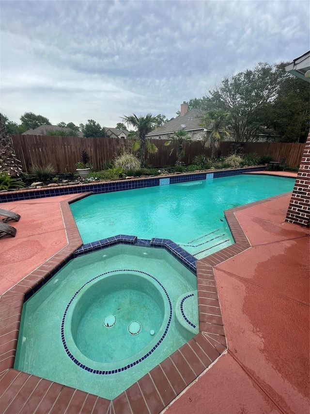 view of swimming pool with an in ground hot tub