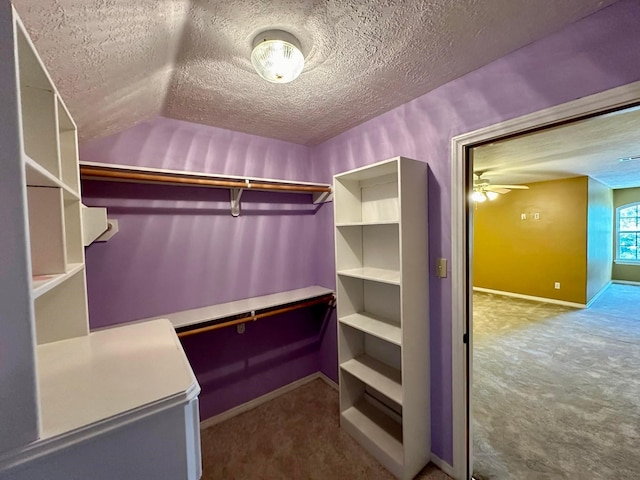 walk in closet with light colored carpet and ceiling fan