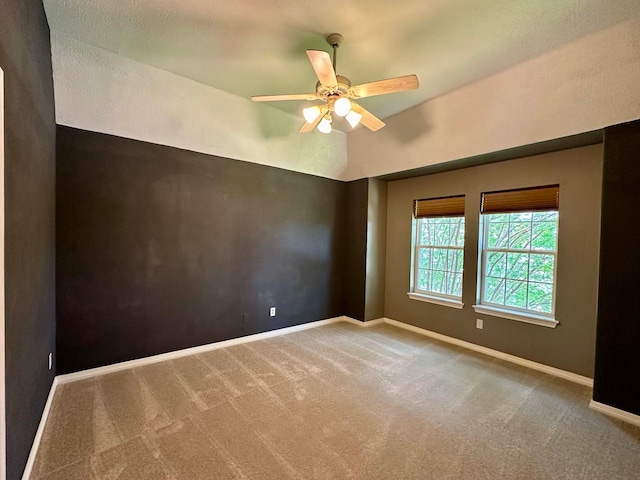 spare room featuring carpet flooring, ceiling fan, and lofted ceiling