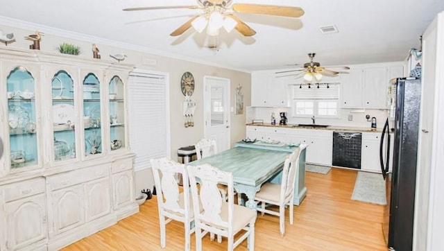 dining room featuring crown molding, sink, and light hardwood / wood-style flooring