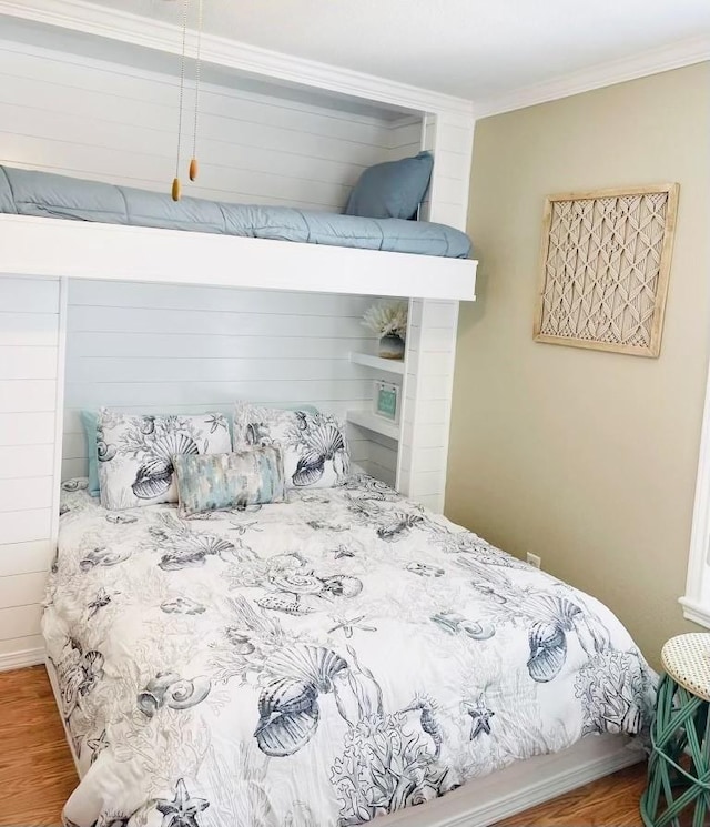 bedroom with hardwood / wood-style flooring and ornamental molding