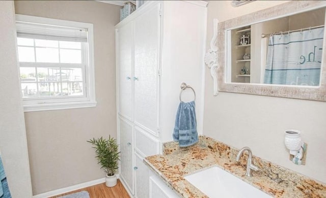 bathroom with vanity, a shower with shower curtain, and hardwood / wood-style flooring