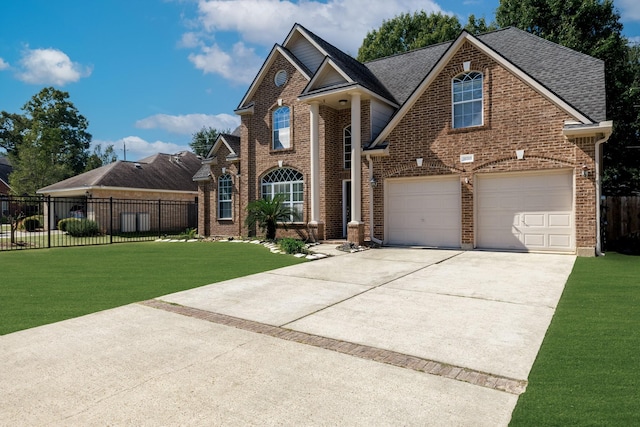 view of property featuring a garage and a front lawn