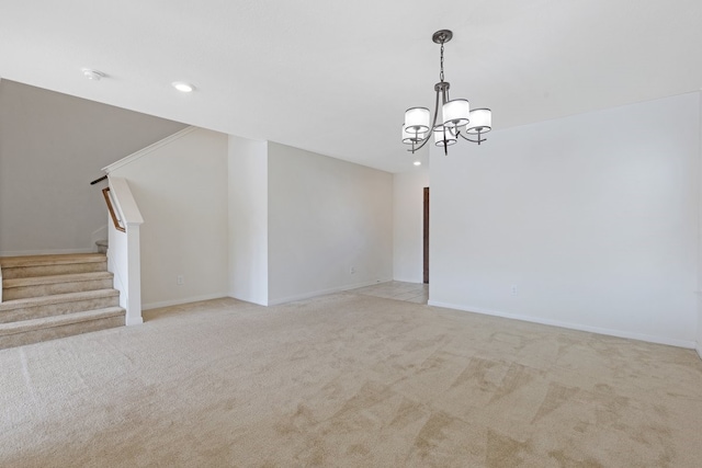 carpeted spare room featuring a chandelier