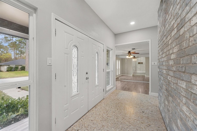 foyer entrance with ceiling fan and a healthy amount of sunlight