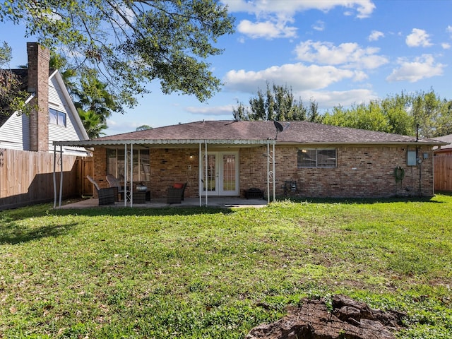 rear view of house featuring french doors, a patio area, and a lawn