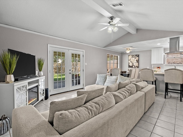 tiled living room featuring vaulted ceiling with beams, ceiling fan, crown molding, and french doors