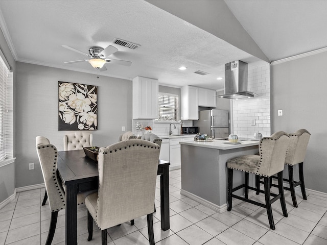 dining area featuring ceiling fan, crown molding, light tile patterned floors, and a textured ceiling