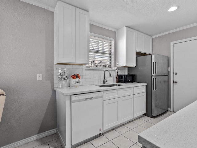 kitchen featuring backsplash, white dishwasher, white cabinetry, and sink