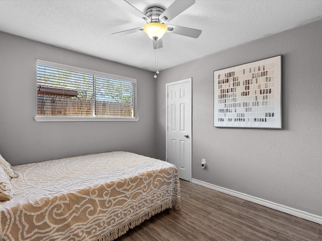 bedroom featuring hardwood / wood-style flooring, ceiling fan, and a textured ceiling