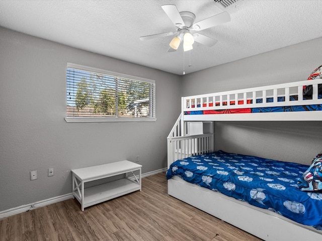 bedroom featuring ceiling fan, a textured ceiling, and hardwood / wood-style flooring