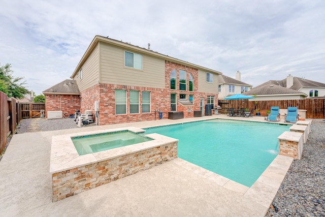 view of pool with an in ground hot tub, a fireplace, and a patio