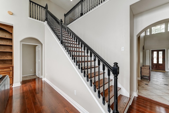 staircase featuring hardwood / wood-style floors and a high ceiling