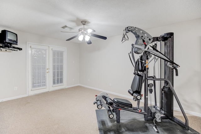 workout room with ceiling fan, carpet floors, and a textured ceiling