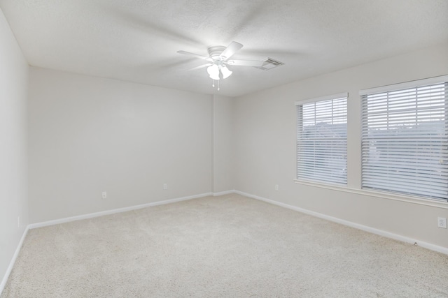 spare room featuring light carpet and ceiling fan