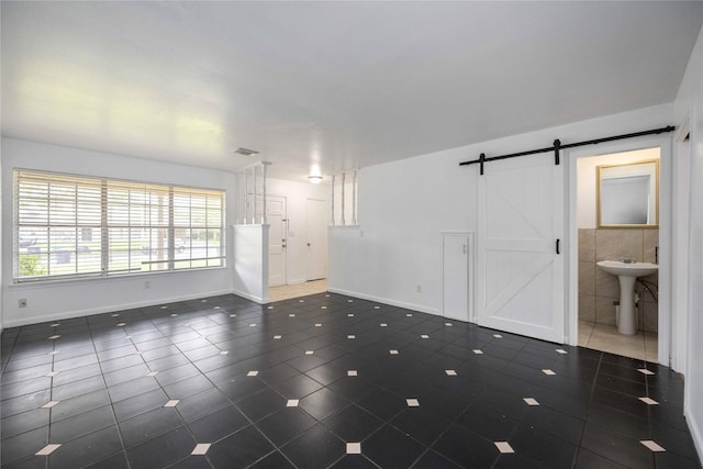 interior space with a barn door, tile walls, and sink