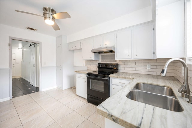 kitchen featuring sink, black electric range, light tile patterned floors, light stone counters, and white cabinetry