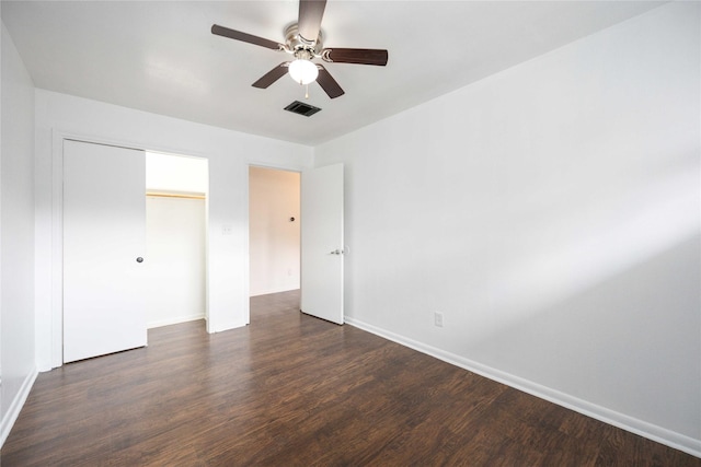 unfurnished bedroom featuring ceiling fan, a closet, and dark wood-type flooring