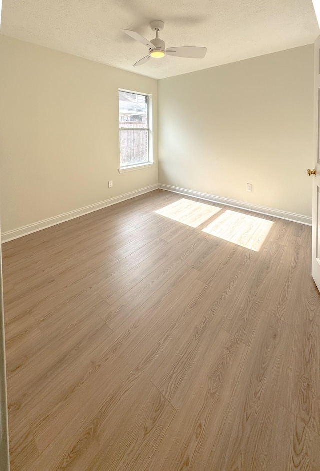 unfurnished room featuring ceiling fan, a textured ceiling, and light wood-type flooring