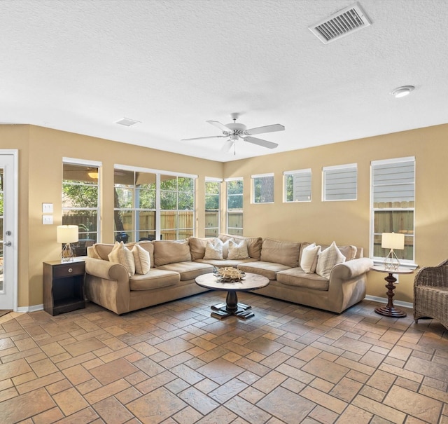 living room featuring a textured ceiling and ceiling fan