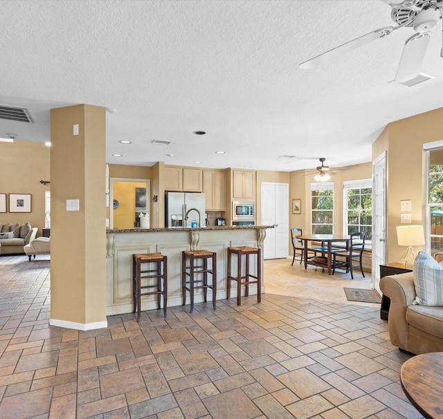 living room featuring a textured ceiling and ceiling fan