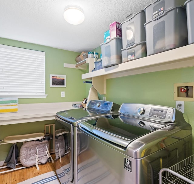 washroom featuring hardwood / wood-style floors, a textured ceiling, and independent washer and dryer