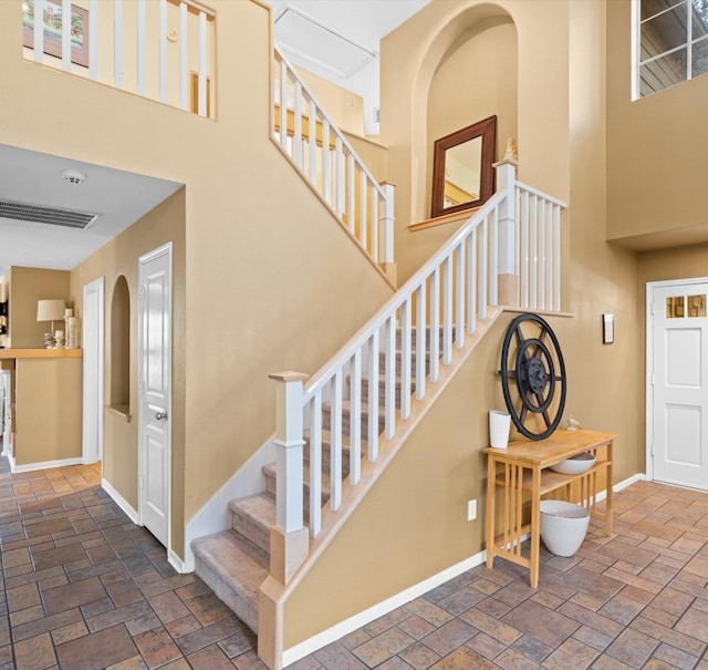 staircase featuring a towering ceiling