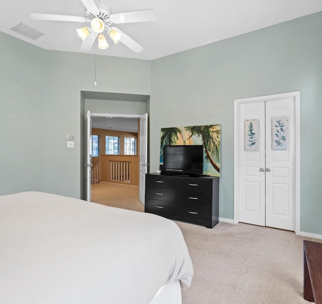 carpeted bedroom featuring ceiling fan and a closet