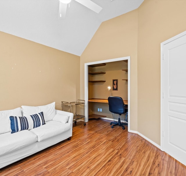 office space featuring light wood-type flooring, built in desk, vaulted ceiling, and ceiling fan