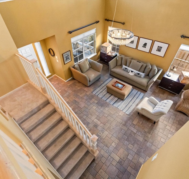 living room featuring a towering ceiling and a notable chandelier