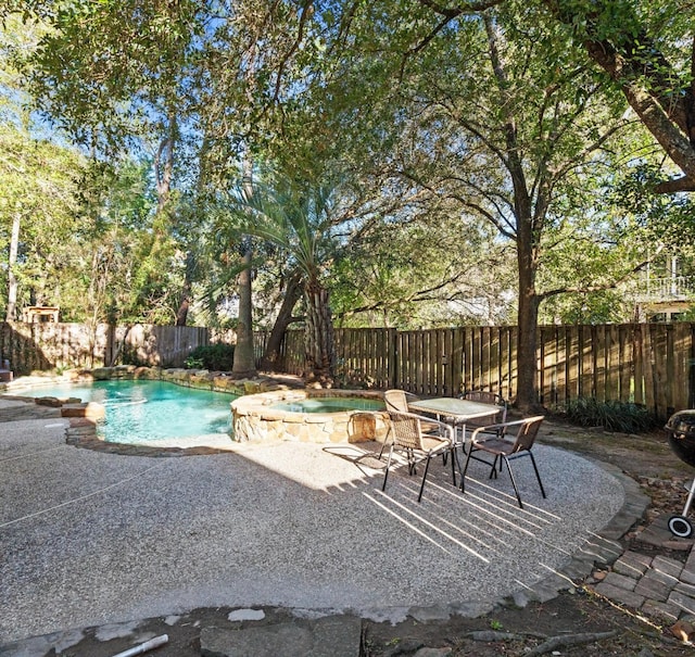 view of swimming pool featuring an in ground hot tub and a patio